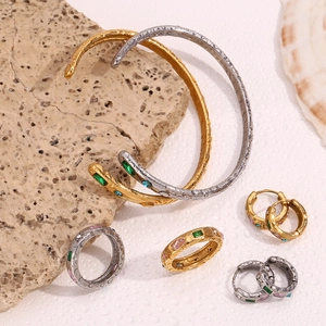 Detail of 18K gold plated jewelry set with water drop gems on white sand and beach shells