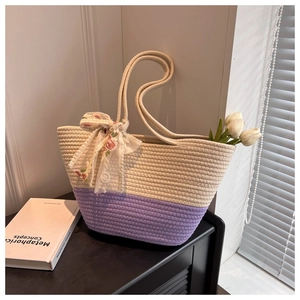 Detail of woven tote bag with a floral mesh bow on handles and contrasting color texture