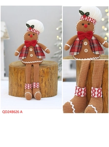 Close-up of sitting gingerbread plush toy with white chef hat and red bowtie decoration
