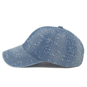 Detail shot of blue denim baseball cap featuring vertical white distressed texture and seams