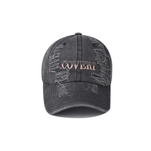 Close-up of distressed washed cotton texture and embroidered Coveri logo on baseball cap