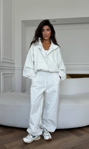 Détail d'un ensemble détente gris clair avec pantalon large à cordon et veste courte