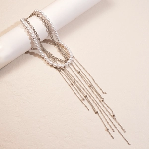 Detail of layered silver tassel necklace with white pearls on a display stand