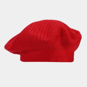 Détail d'un béret en tricot rouge orné de rangées verticales de strass brillants