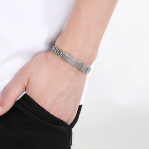 Close-up of a silver braided snake chain bracelet on wrist for men's fashion