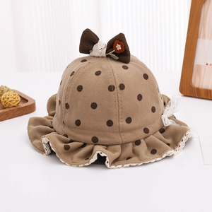 Détail d'un chapeau cloche bébé à pois avec nœud marron et bordure en dentelle blanche