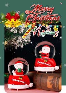 Close-up of Santa Claus snow globe on vintage books with festive lights and ornaments