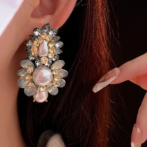 Boucles d'oreilles fleurs vintage avec perles et cristaux portées par un mannequin
