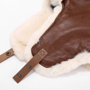 Brown leather trapper hat with white faux fur lining and chin strap for winter