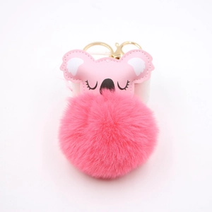 Detail of pink koala pompom keychain with golden metal hardware and fluffy faux fur ball