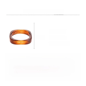 Detail view of brown resin square bangle showing 7.5cm dimensions and amber texture