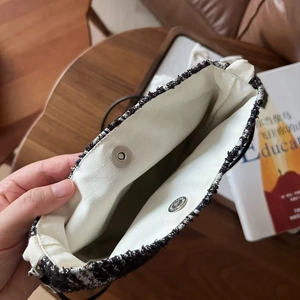 Detail view of tweed crossbody bag interior with canvas lining and dual magnetic buckles