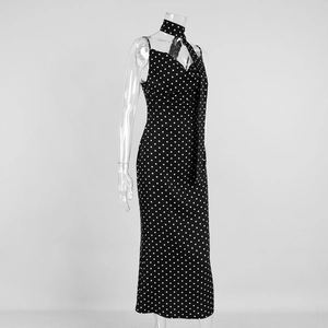 Detail of black polka dot dress featuring thin straps and matching neck tie accessory