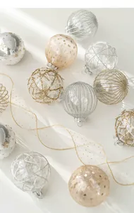 Detail of 8cm festive Christmas ornaments with elegant gold patterns and silk ribbons