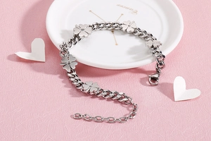 Detail of silver clover bracelet with flat metal clovers and chunky horsebit chain links