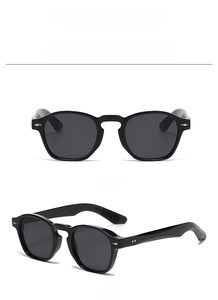 Detailed front and side view of classic black round sunglasses with silver stud accents