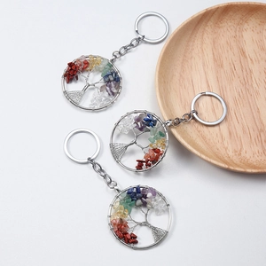 Three tree of life keychains with colorful natural crystal stone chips on white background