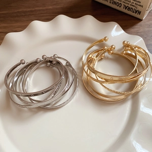 Detail of gold and silver open bangles with LOVE engraving on a ceramic plate