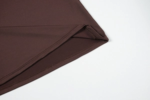 Detailed macro view of the dark brown jersey dress featuring clean double-needle coverstitch hem
