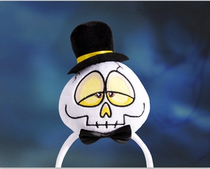 Detail of Halloween plush headband with white skull wearing a black top hat and bow tie