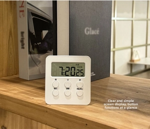 Close-up of a white magnetic digital timer with LCD display and 6 physical buttons
