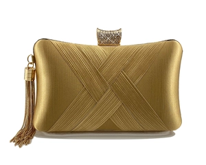 Detail of gold evening clutch with pleated texture, diamond buckle and metal tassels