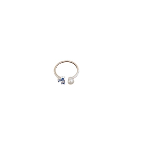 Silver open ring featuring a white pearl and three square blue zircons on a white background