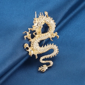 Broche dragon dorée aux écailles détaillées sur fond en soie bleu pour costume homme