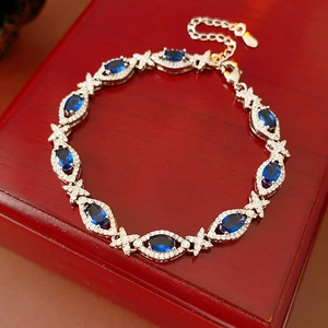 Detail of sapphire oval bracelet with silver cubic zirconia on a red wood box