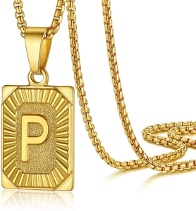 Macro shot of gold rectangle pendant with engraved letter P on a box chain
