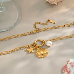 Elegant 18K gold starfish and pearl pendant necklace on a paperclip chain for beach vacation