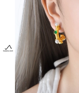 Détails de boucles d'oreilles vintage en or avec émeraude et perles portées