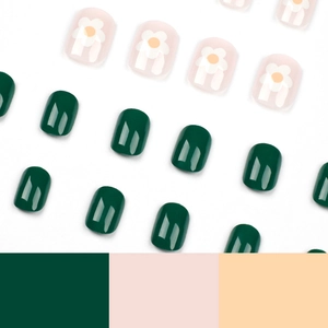 Glossy green and pink press-on nails with white floral patterns on a white background