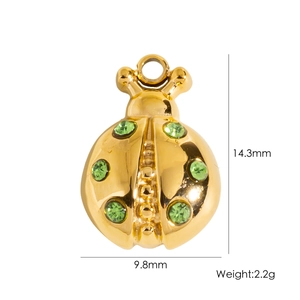 Macro shot of gold ladybug pendant with green crystal showing 14.3mm height and 2.2g weight