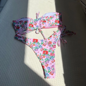 Gros plan du tissu de bikini floral avec imprimé coloré et liens sur le côté du bas