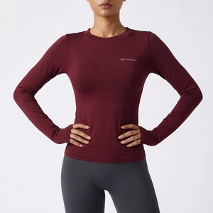 Détail du haut de sport à manches longues bordeaux avec logo et texture jacquard