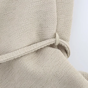 Detail of beige chunky knit fabric with a matching textured belt for spring dresses
