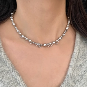 Elegant vintage faux pearl necklace with zircon star charms worn on a V-neck sweater