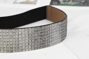 Detailaufnahme glitzernder Silber-Strasssteine auf elastischem, breitem Modegürtel