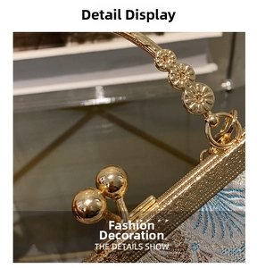 Macro view of vintage embroidered handbag with ornate floral metal handle and gold clasp