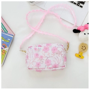 Detailed macro view of 3D lace floral embroidery and shimmering sequins on a white crossbody bag