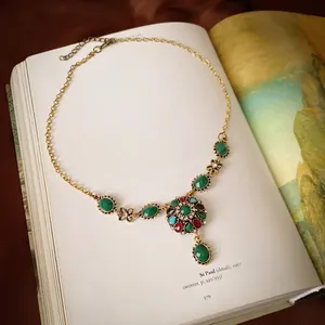 Vintage gold necklace set with multi-color rhinestones on a retro floral art book