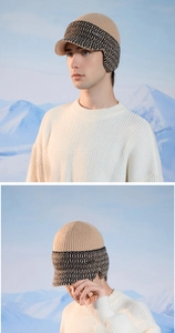 Detail of men's beige knitted winter hat with earflaps and stylish geometric patterns
