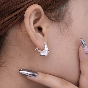 Silver geometric U-shaped crescent earrings with a polished stainless steel finish on a model