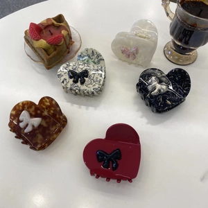 Collection of five heart-shaped acetate hair claws with delicate ribbon bow accents