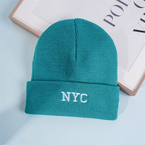 Detail of teal knit beanie featuring white NYC embroidery and premium ribbed texture