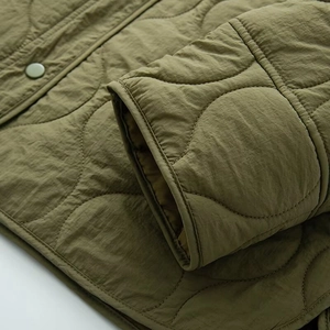 Detailaufnahme der armygrünen Steppjacke mit Zwiebelsteppmuster und Metalldruckknöpfen