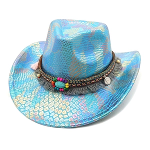 Détail du chapeau de cowboy effet serpent coloré avec perles ethniques et pompon turquoise