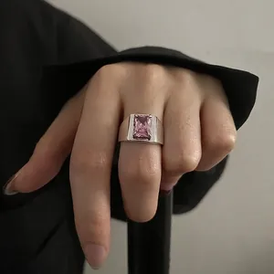 Minimalist wide band ring with a large rectangular pink zircon in a claw setting