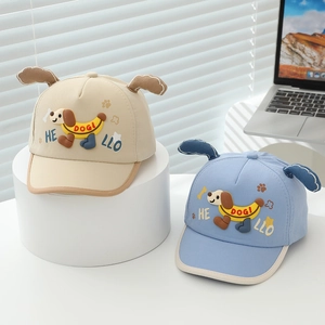 Detail of beige and blue toddler baseball caps with cartoon dog ears and embroidery